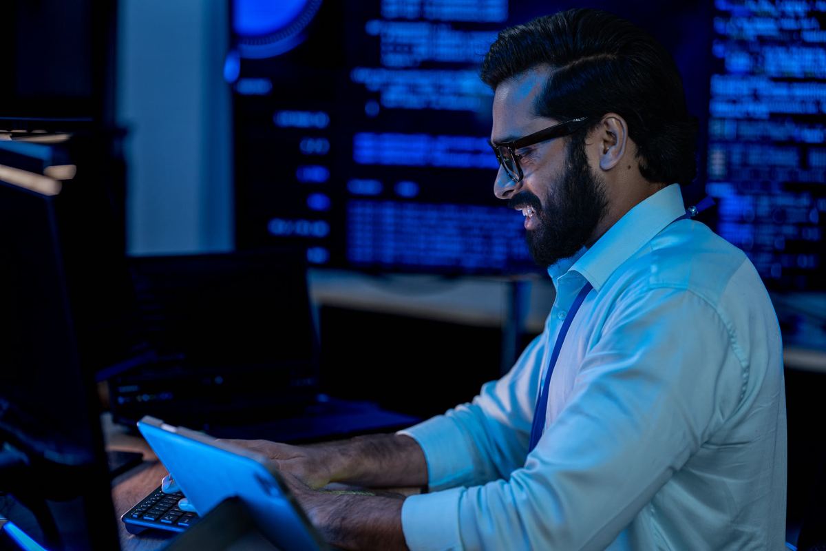Security analyst monitoring multiple screens in a dark operations room